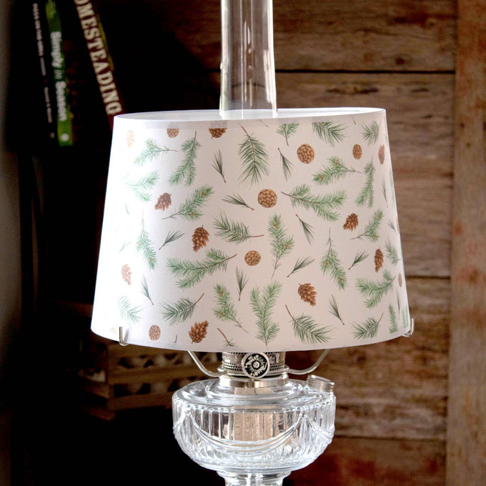 Handcrafted parchment lamp shade featuring delicate pine bough and pinecone patterns, softening light for a cozy ambiance; ideal for Lamps & Lighting, Parts and Accessories, and Lamp Shades collections.