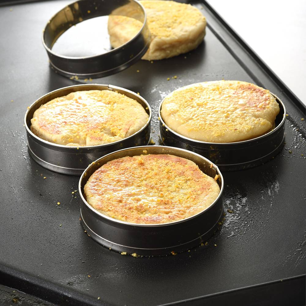 Four stainless steel rings holding cooking English muffins on a griddle, perfect for Kitchen & Food, Kitchen Gadgets, Cooking and Baking Helpers, Best Sellers, and Promo Eligible collections.