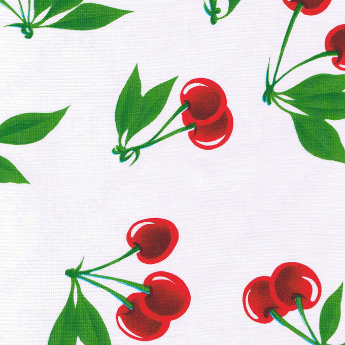 Close-up of a vintage-inspired wipe-clean vinyl tablecloth featuring bright red cherries and green leaves on a white background, perfect for Home & Decor and Kitchen Textiles collections.