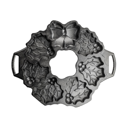 Seasoned cast iron cakelet pan shaped like a holiday wreath with holly leaves, berries, and bow details, ideal for even baking in Kitchen & Food and Cast Iron collections.