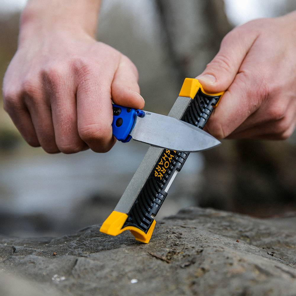 Person sharpening a folding blade knife using a compact Work Sharp pocket knife sharpener with black body and yellow corner grips, suitable for Farm, Garden & Tool and Knives & Axes collections.