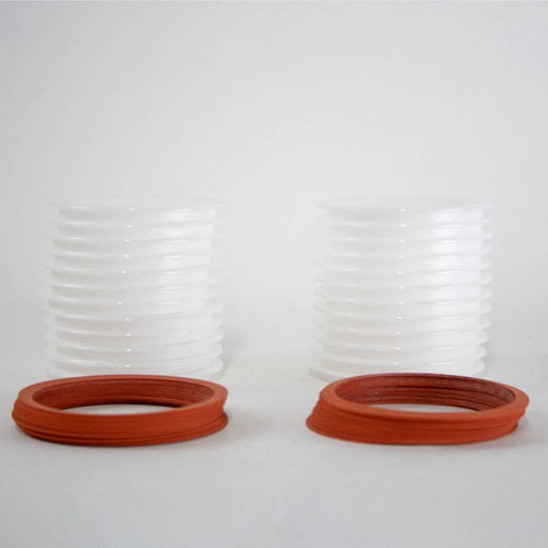 Two stacks of translucent wide-mouth reusable plastic canning lids paired with orange sealing rings, made in USA for Kitchen & Food, Food Preservation, and Canning collections.