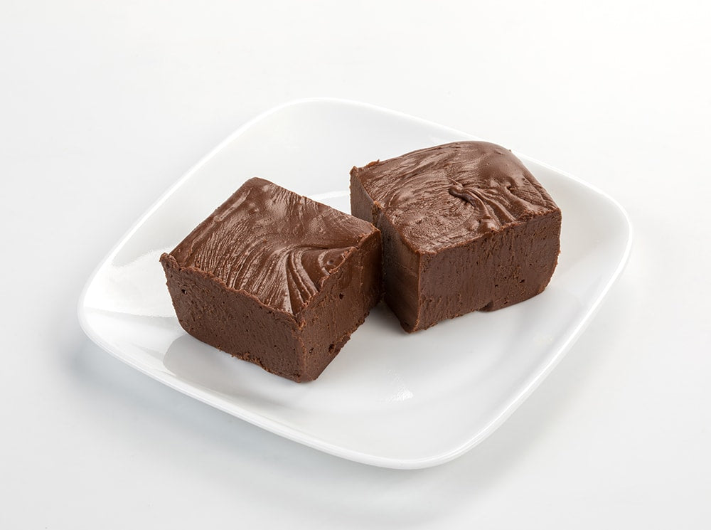 Two handcrafted rich chocolate fudge squares with a smooth, creamy texture on a white plate, featured in Kitchen & Food, Snacks and Sweets, USA Made, Best Sellers, and Promo Eligible collections.