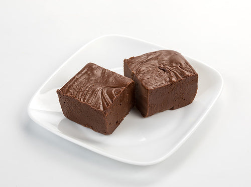 Two handcrafted rich chocolate fudge squares with a smooth, creamy texture on a white plate, featured in Kitchen & Food, Snacks and Sweets, USA Made, Best Sellers, and Promo Eligible collections.