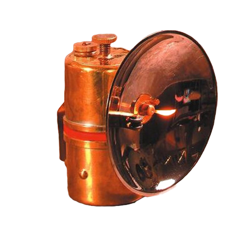 Solid brass carbide lamp with flint striker producing bright white flame, designed for durable use in camping, barn, and outdoor lighting applications.