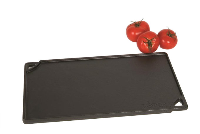 Rectangular cast iron griddle with a smooth cooking surface, corner pour spouts, and embossed logo, accompanied by fresh tomatoes, ideal for Kitchen & Food and USA Made cookware collections.