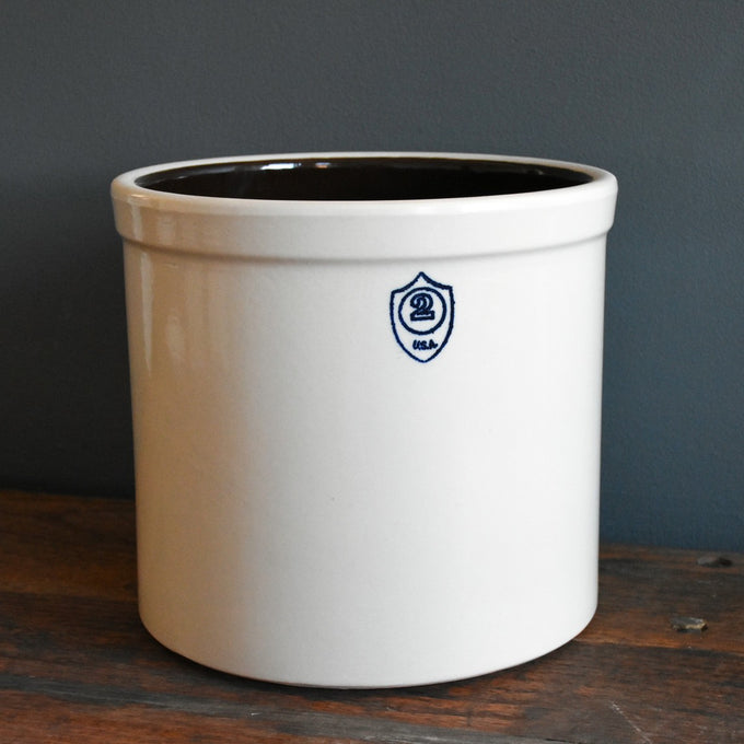 Cream-colored 2 gallon stoneware crock with dark glazed interior and stamped number, handcrafted in USA, perfect for food preservation, fermenting, and pickling.