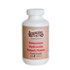 White plastic container with a screw-on lid labeled for potassium hydroxide potash flakes, food grade, 2-pound size, handcrafted and made in the USA, featured in soapmaking and health collections.