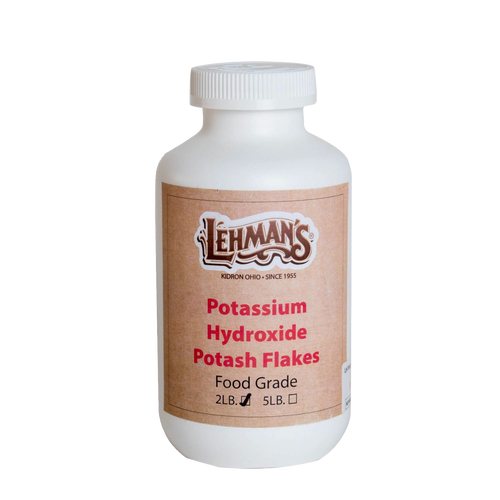 White plastic container with a screw-on lid labeled for potassium hydroxide potash flakes, food grade, 2-pound size, handcrafted and made in the USA, featured in soapmaking and health collections.