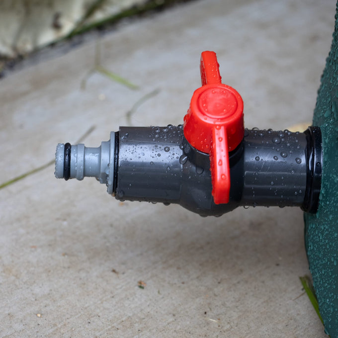 Close-up of a durable plastic spigot with a bright red handle attached to a garden water barrel, featured in Farm, Garden & Tool, Garden Accessories, Lawncare, Best Sellers, and Promo Eligible collections.