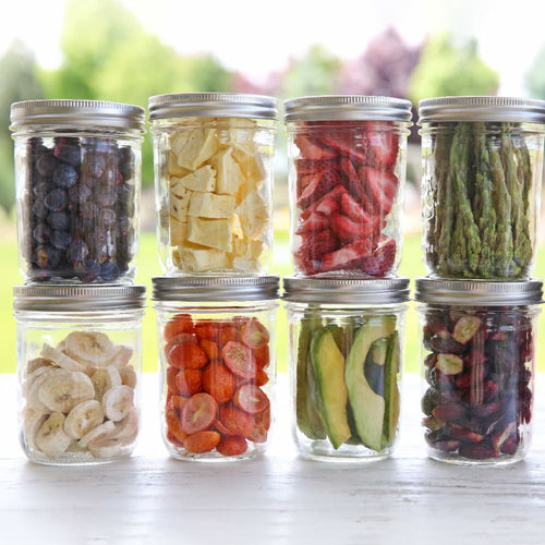 Eight glass jars filled with various freeze-dried fruits and vegetables including blueberries, bananas, tomatoes, avocado, and asparagus, perfect for Kitchen & Food and Food Preservation collections.