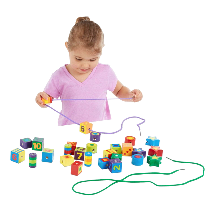 Young child playing with colorful handcrafted wooden lacing beads in various shapes and numbers, designed to support fine motor skills and indoor play in children's toy collections.