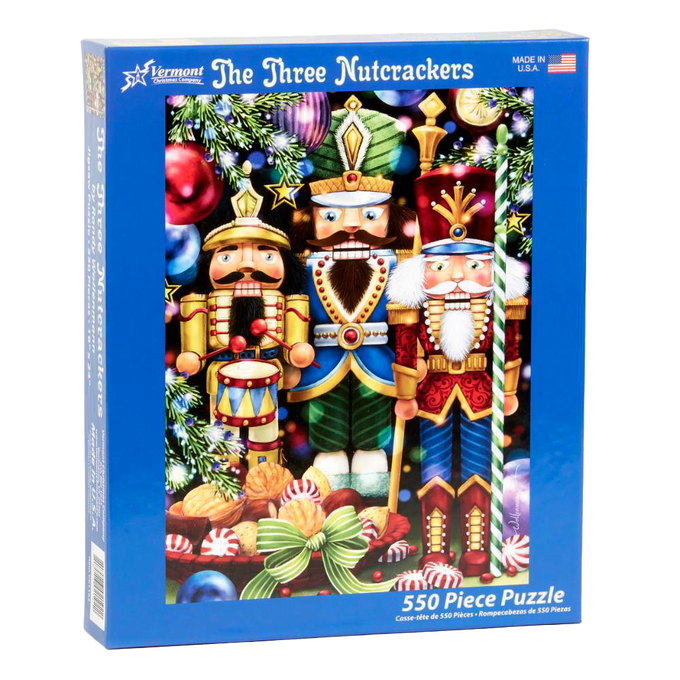 Blue box featuring a colorful holiday-themed puzzle of three detailed nutcrackers surrounded by ornaments and festive decorations, handcrafted and made in USA, ideal for Toys, Books & Games, Games and Puzzles, Puzzles, Best Sellers, and Promo Eligible collections.