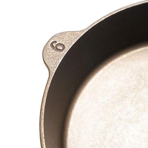Close-up of a handcrafted, Amish-made cast iron skillet marked with the size "6," featuring a smooth, durable surface, ideal for Kitchen & Food, Cast Iron, USA Made, and Camping collections.