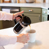 Pouring coffee from a stainless steel framed French press with black lid and handle into a white mug on a kitchen countertop, featured in Kitchen & Food, Brewing Coffee and Tea, Best Sellers, and Promo Eligible collections.