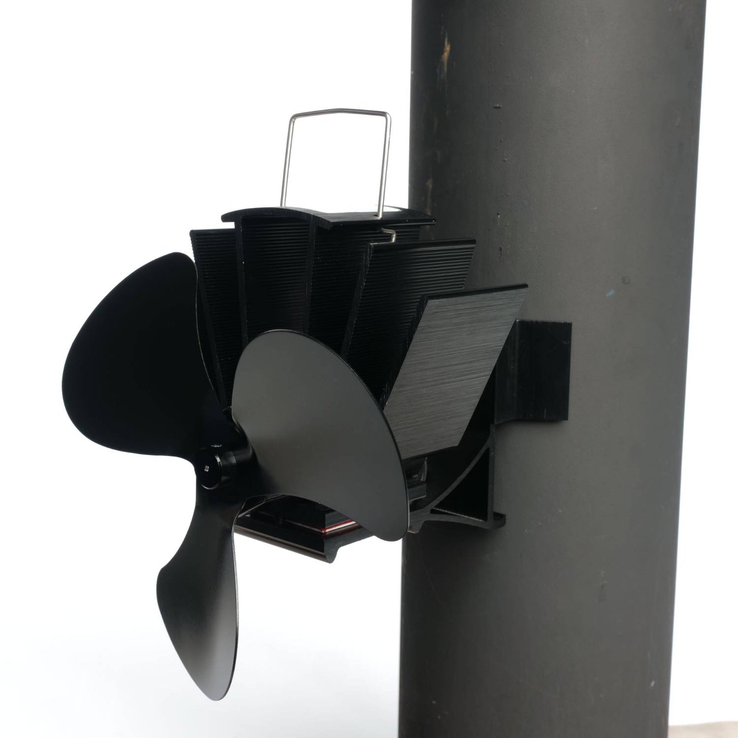 Black three-bladed magnetic stove fan mounted on a flue pipe with metal fins for heat-powered air circulation, featured in Stoves, Hearth Accessories, Best Sellers, and Promo Eligible collections.