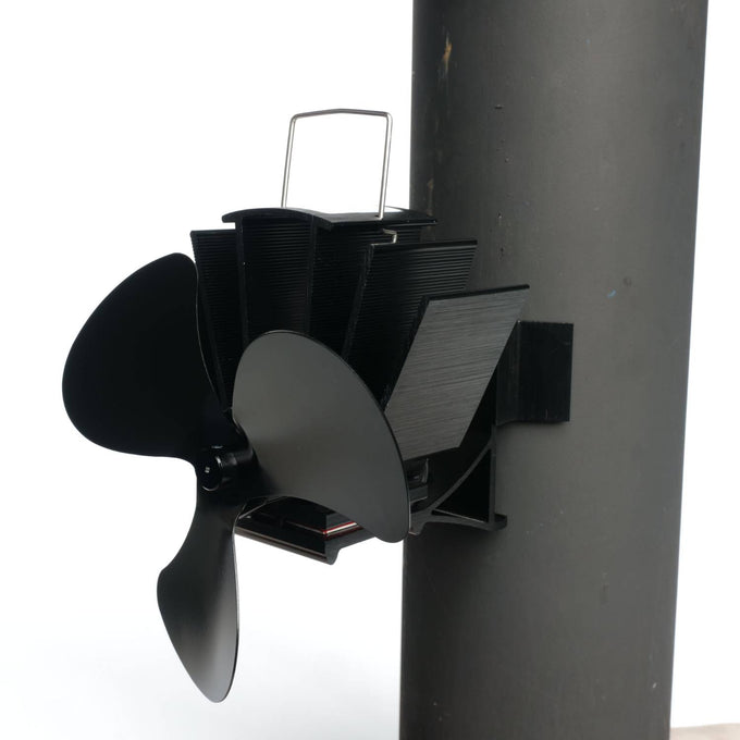 Black three-bladed magnetic stove fan mounted on a flue pipe with metal fins for heat-powered air circulation, featured in Stoves, Hearth Accessories, Best Sellers, and Promo Eligible collections.