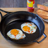 Handcrafted lightweight cast iron skillet made in USA with two sunny-side-up eggs garnished with chives and hot sauce, shown alongside toasted bread for Kitchen & Food and Cookware collections.