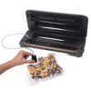Black automatic vacuum sealer with integrated bag cutter sealing a clear bag of mixed nuts and candy, ideal for Kitchen & Food, Food Preservation, Freezing, and Best Sellers collections.