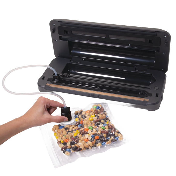 Black automatic vacuum sealer with integrated bag cutter sealing a clear bag of mixed nuts and candy, ideal for Kitchen & Food, Food Preservation, Freezing, and Best Sellers collections.