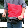 Person holding a red nylon shoulder spreader with a black base and crank handle, designed for evenly dispersing seeds or granular material, part of Farm, Garden & Tool, Seeds and Planting, USA Made, Best Sellers, and Promo Eligible collections.