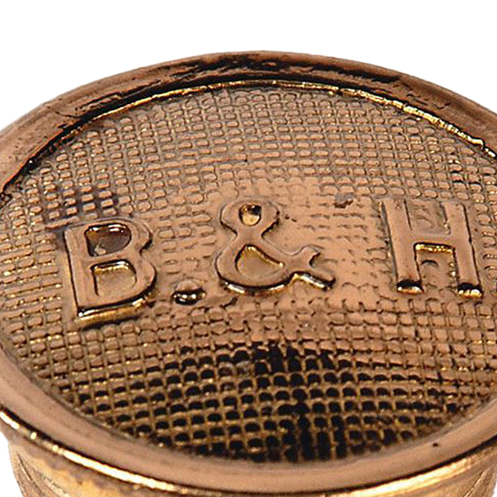 Close-up of a polished brass filler cap embossed with B&H logo, featuring textured surface and smooth rim, suitable for lamps and lighting parts in Best Sellers collection.