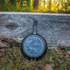 Handcrafted cast iron skillet with an embossed duck design resting outdoors against weathered wood, ideal for Kitchen & Food, Cookware, Cast Iron, USA Made, Best Sellers, and Promo Eligible collections.