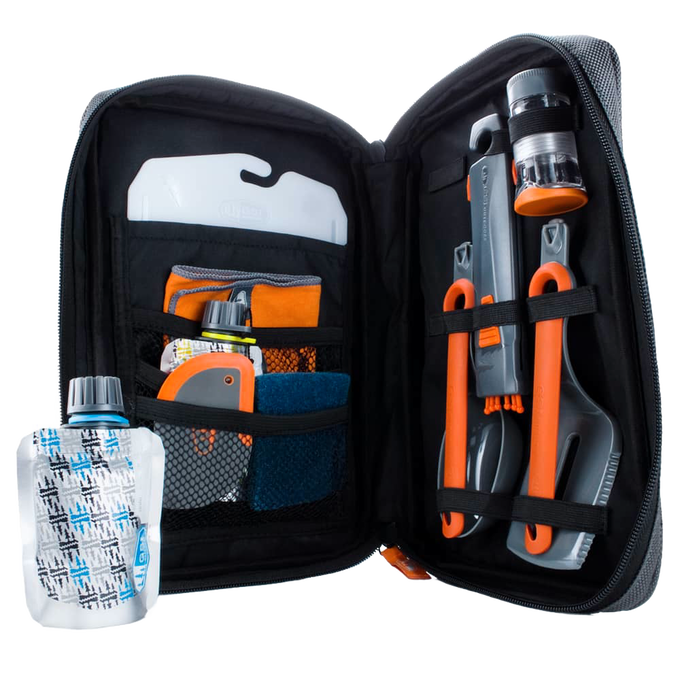 Compact black zippered case opened to reveal an organized 11-piece orange and gray camping kitchen set with utensils, collapsible containers, and cleaning tools, ideal for outdoor cooking and camping gear collections.