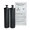 Two black cylindrical water filter elements standing beside a white informational card detailing quality and testing for gravity-fed water filtration, featured in appliances and water treatment collections.