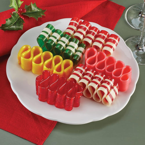 Handcrafted handspun ribbon candy in assorted flavors and colors, arranged on a white plate with festive holly, ideal for Kitchen & Food, Snacks and Sweets, and USA Made collections.