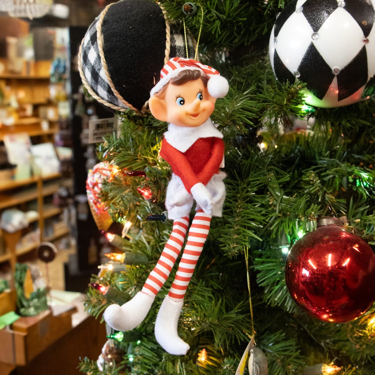 Posable vintage-style Christmas pixie elf ornament with fabric body, striped legs, and hanging cord, featured in Holiday Decor and Home & Decor collections.