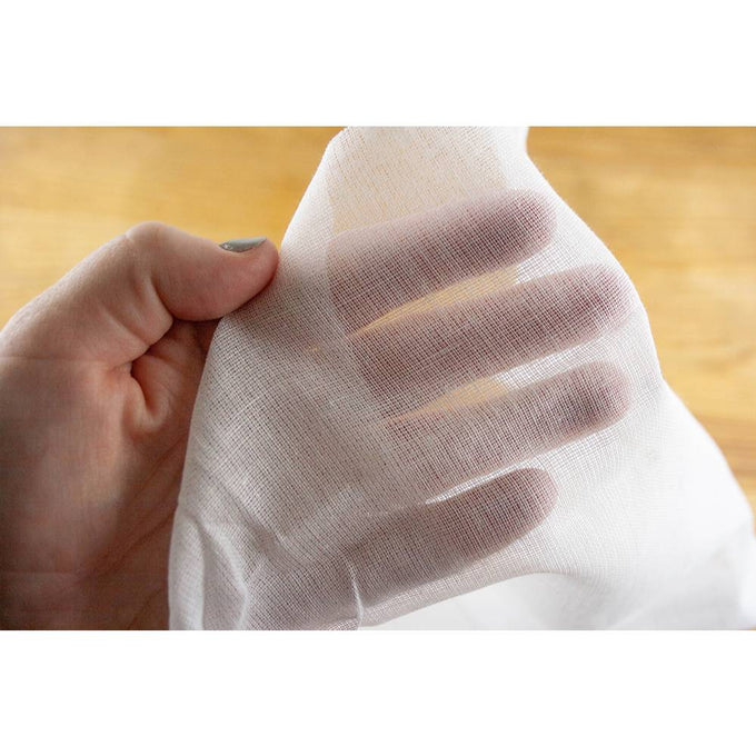 Hand holding a piece of finely woven heavy-duty cotton muslin, a handcrafted essential for cheesemaking, suitable for Kitchen & Food, Specialty Equipment, and DIY Cheese collections.