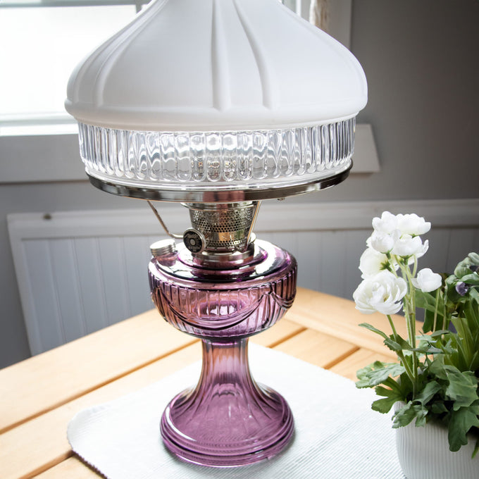 Handcrafted oil lamp featuring a rich amethyst glass base, polished brass burner, and white frosted top shade with clear ribbed glass, suitable for Farm, Garden & Tool, Emergency Supplies, and Lamps & Lighting collections.