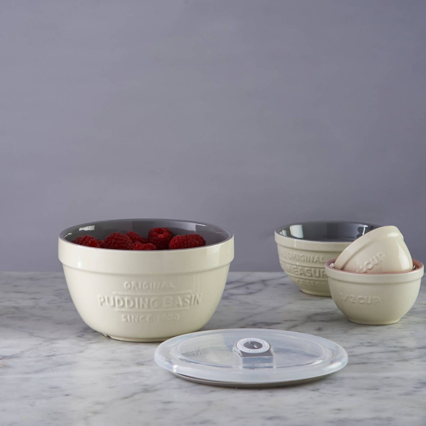 Cream-colored Mason Cash all-purpose bowl filled with fresh raspberries beside smaller nested bowls and a clear vented lid, styled for Kitchen & Food, Cookware, Baking Supplies, Storage and Serving, Best Sellers, and Promo Eligible collections.