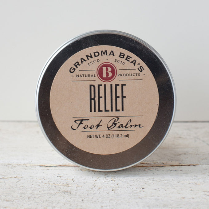 Round metal tin of handcrafted natural relief foot balm with simple kraft paper label, made in USA, featured in Health & Wellness, Balms, Creams and Lotions, and Best Sellers collections.