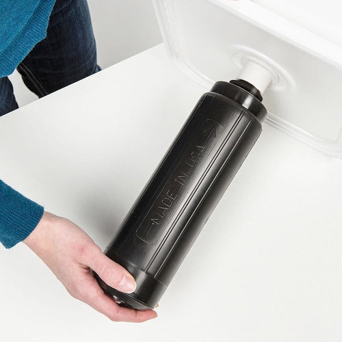 Handheld black multi-media cartridge labeled made in USA, being installed or removed from a white water filter container, part of Appliances and Water Heating and Treatment collections.