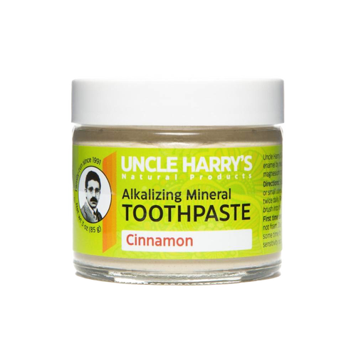 Small glass jar of handcrafted alkalizing mineral toothpaste in cinnamon flavor with a bright yellow label, promoting natural health and wellness and American-made grooming care.