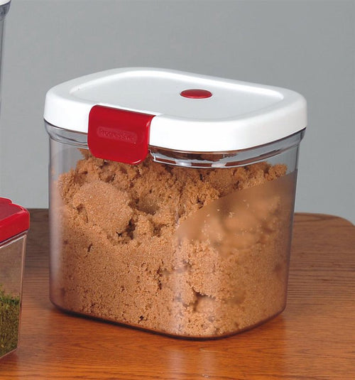 Clear BPA-free plastic container with a white snap-shut lid and red clasp, filled with fresh brown sugar, featuring a terra cotta moisture keeper inside, suitable for Kitchen & Food, Storage and Serving collections.