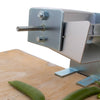Close-up of a metal pea sheller with a clamp base attached to a wooden surface, featuring a sturdy shaft for hand or motorized use, suitable for Kitchen & Food, Specialty Equipment, Peelers and Pitters, USA Made, Best Sellers, and Promo Eligible collections.