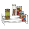 Chrome-finished 3-tier rack holding assorted pantry items including a jar of olives, a spice container with cinnamon sticks, and several canned goods, ideal for kitchen organization and storage.