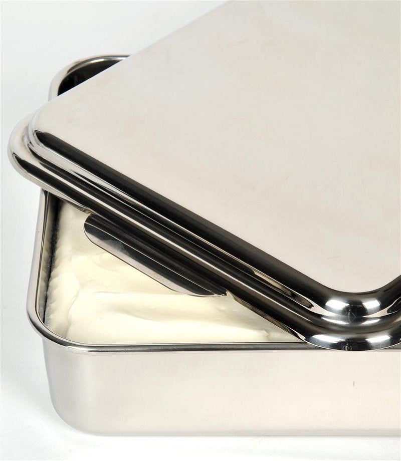 Close-up of a handcrafted stainless steel cake pan with a partially open lid showing a white creamy dessert inside, ideal for holiday hosting and baking supplies.