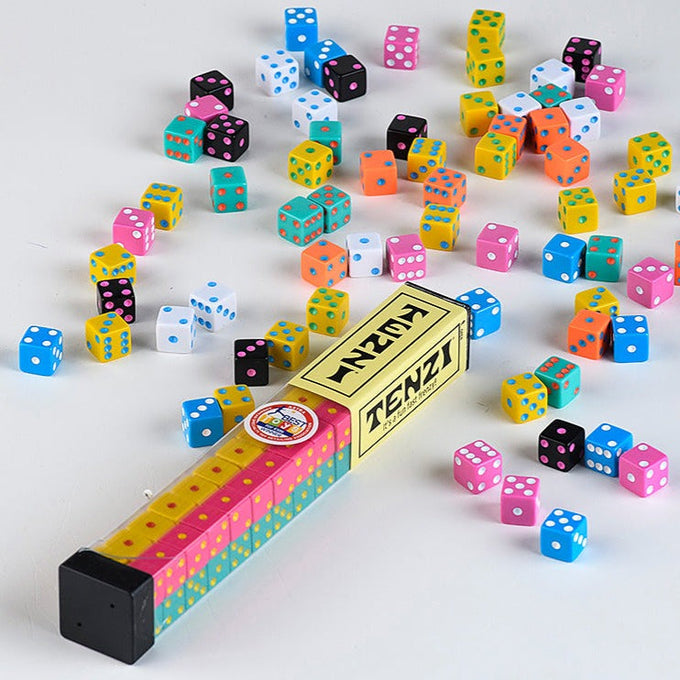 Colorful Tenzi dice scattered around a clear plastic container with a vintage-style label on a plain background, featured in Toys, Books & Games, Table and Board Games, Best Sellers, and Promo Eligible collections.