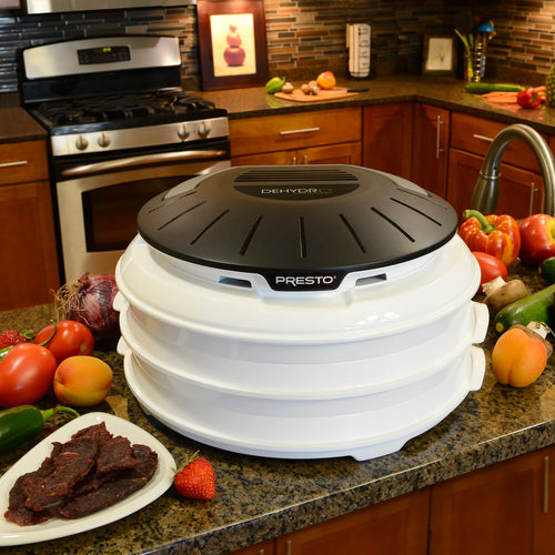 Compact white electric food dehydrator with stackable nesting trays and black vented lid, shown on kitchen counter with fresh produce and beef jerky, ideal for Kitchen & Food and Food Preservation collections.
