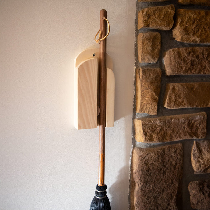 Handcrafted Amish made wooden wall broom holder mounted beside a rustic stone wall, designed for organized storage in Home & Decor, Household Helpers, and Cleaning Utensils collections.