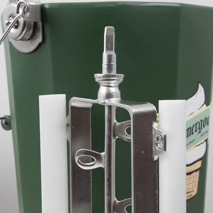 Close-up view of a polished stainless steel freezing paddle assembly with white plastic blades attached to the hand-crank mechanism on a handcrafted green Amish-made ice cream freezer bucket, part of kitchen and specialty food equipment collections.