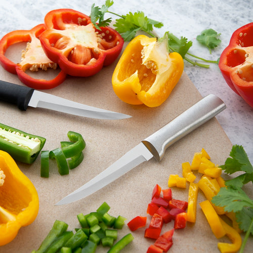 Two handcrafted Rada Super Parer knives with solid aluminum and black handles, slicing colorful bell peppers on a cutting board, ideal for kitchen and food prep collections.