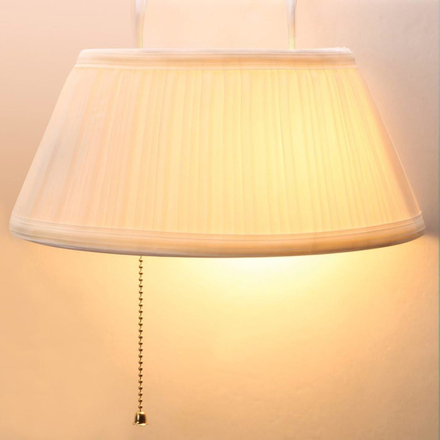 Cream-colored pleated fabric lampshade with pull chain hanging softly, designed for easy bedside lighting in home, camping, and outdoor electric light collections.