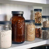 Set of six textured dark lids sealing wide mouth glass jars filled with various pantry staples like flour, rice, nuts, and seeds, ideal for Kitchen & Food, Storage and Serving, Best Sellers, and Promo Eligible collections.