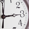 Close-up view of a handcrafted cast iron skillet clock face with elegant black hands and numerals on a light green undertone, made in USA, featured in Home & Decor and Cast Iron collections.