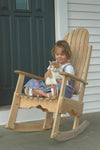 Handcrafted durable cypress rocking chair made in USA with slatted back, shown with child holding a cat on front porch, ideal for Home & Decor, Indoor and Outdoor Furniture collections.